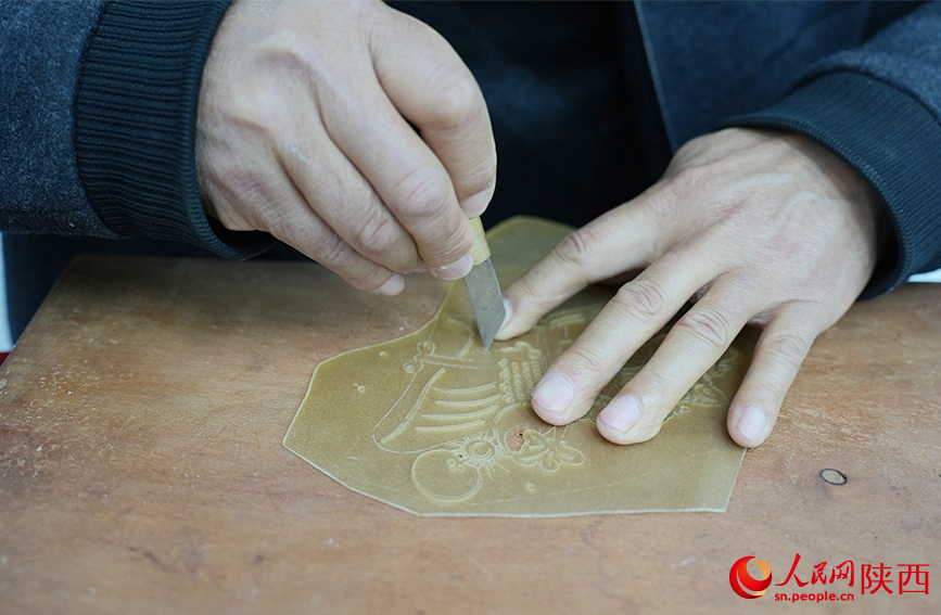 陳義文正在進行雕刻皮影。人民網記者 孫挺攝